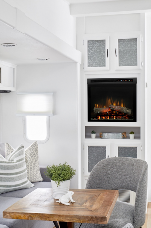 Electric fireplace insert on the wall of a brightly-lit RV
