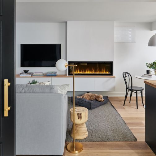 Cozy basement with a dog lying in front of a linear electric fireplace