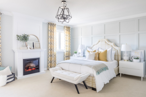 White mantel electric fireplace in a cozy, bright bedroom