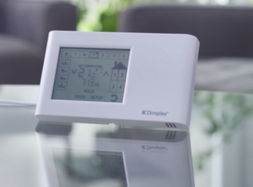 electric thermostat on a glass table with the reflection showing the thermostat