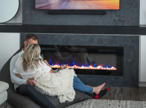 Couple siting beside each other in front of Sierra fireplace