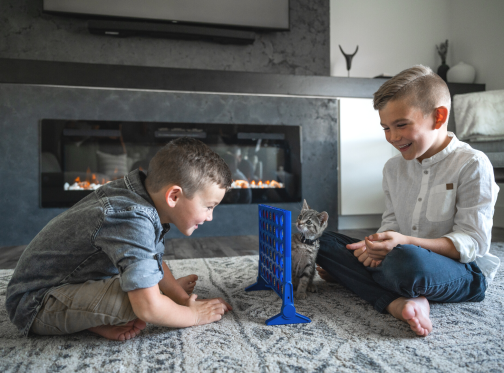 children playing connect 4 by fireplace