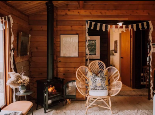 Electric fireplace made to look like a traditional wood burning fireplace, in a rustic log cabin