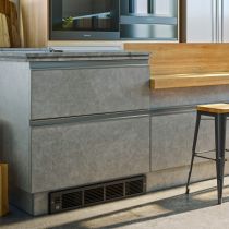 A wall heater mounted in the kick space of a kitchen bench by the floor